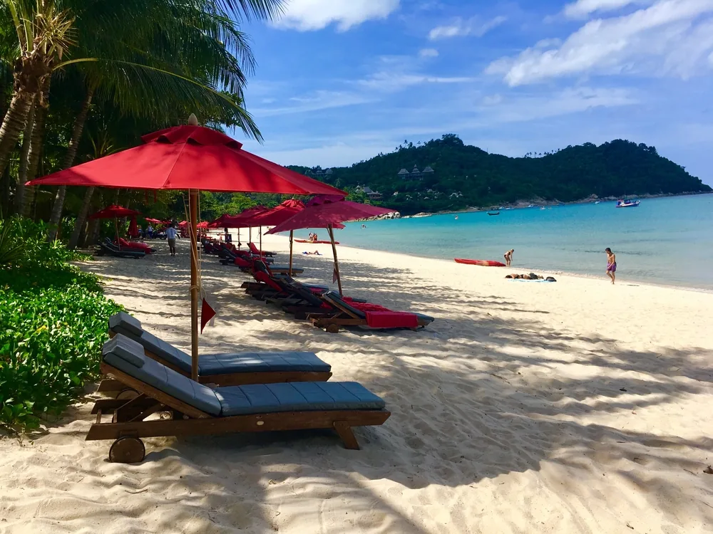 Beach sun loungers and red umbrellas on Thong Nai Pan, Koh Phangan